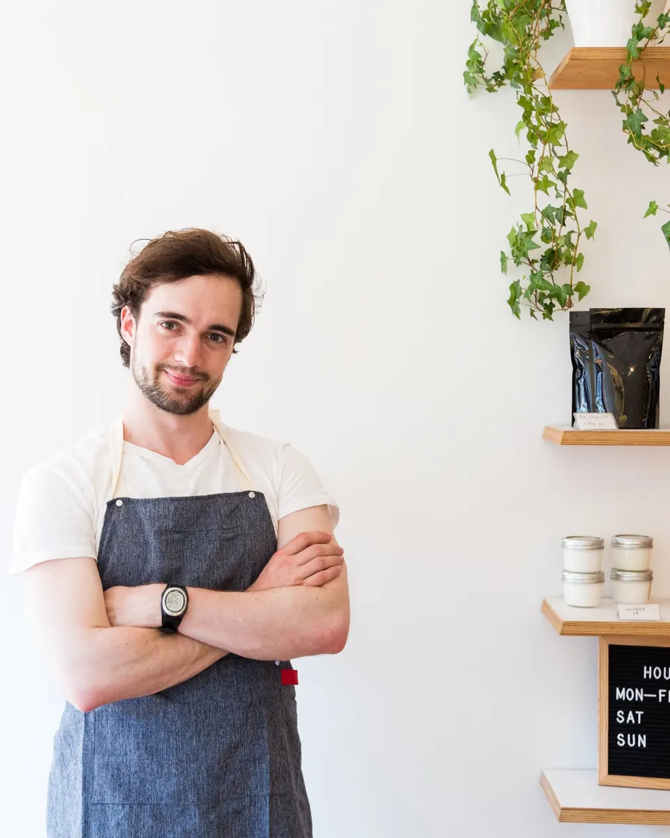 Smiling small business owner in an apron standing in his shop