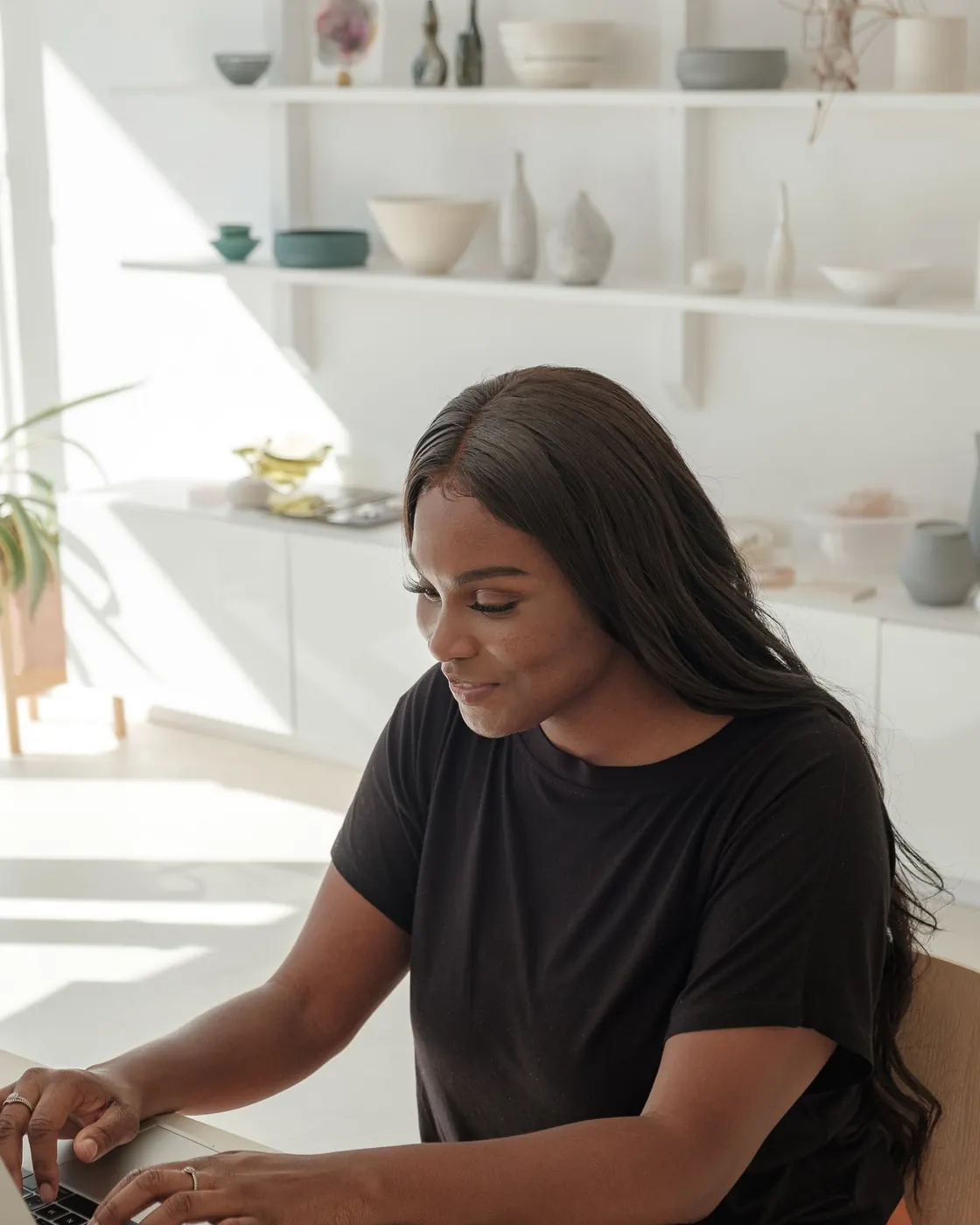 Smiling online store owner checking her shop on a laptop