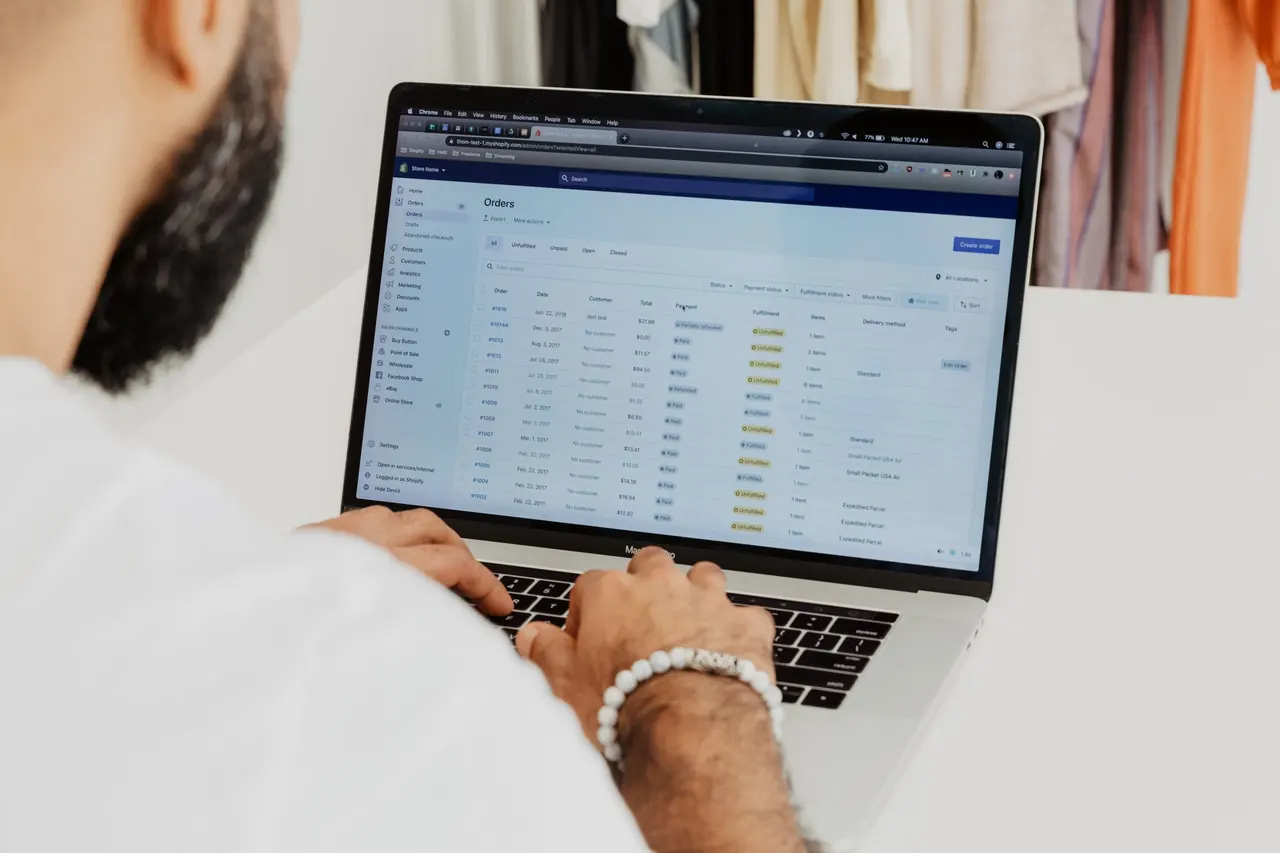 Online store owner reviewing customer orders on a laptop